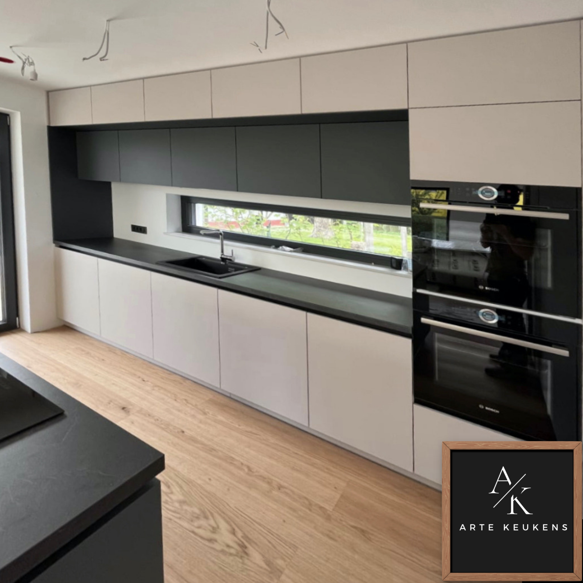 Strakke maatwerk keuken met panoramavenster en geïntegreerde apparatenwand